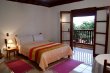 cama do chalé Crisântemo e ao fundo a sacada.