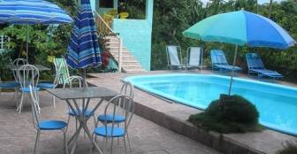 área de lazer, a piscina com churrasqueiras ao fundo