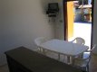 Sala com TV, mesa e sofá :: Chalés Boracéia - Bertioga SP Sala com TV, mesa e sofá :: Chalés Boracéia - Bertioga SP